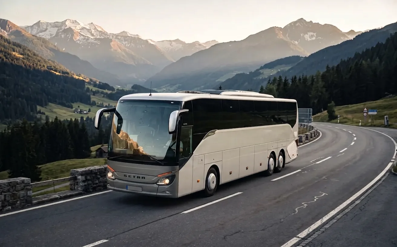 Modern luxury touring coach on an Alpine valley road in Europe, part of the Managed Charter vetted operator network